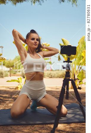 Woman record video workout class on cellphone 82780631
