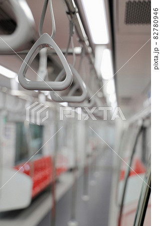 The gray hanging handhold use for standing passengers in a modern metro or train. Suburban and urban transport, with shallow focus. The gray hanging handhold use for standing passengers in a modern metro or train. Suburban and urban transport, with shallow focus. 82780946