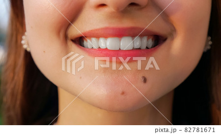 unrecognizable young woman with straight white teeth smiling at camera unrecognizable young woman with straight white teeth smiling at camera 82781671