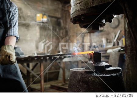 Man forging the iron in the workshop Man forging the iron in the workshop 82781709