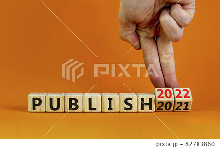 2022 publish and new year symbol. Businessman turns wooden cubes, changes words publish 2021 to publish 2022. Beautiful orange background, copy space. Business, 2022 publish and new year concept. 82783860