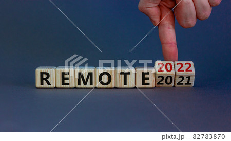 Planning 2022 remote new year symbol. Businessman turns wooden cubes and changes words 'remote 2021' to 'remote 2022'. Beautiful grey background, copy space. Business, 2022 remote new year concept. 82783870