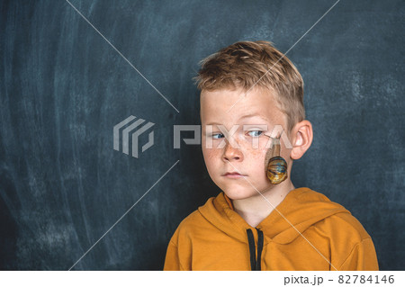 Funny kid boy portrait with Helix Pomatia snail on face. Child playing with pet giant snail. Disgusting snail. Pet at home. Take care. Boy afraid of unusual animals. Snail with brown striped shell 82784146