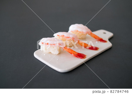 Prawn sushi in japanese restaurant. Sushi - ama Ebi Nigiri on white board isolated on black background. Shrimp sushi. High quality photo Prawn sushi in japanese restaurant. Sushi - ama Ebi Nigiri on white board isolated on black background. Shrimp sushi. High quality photo 82784746