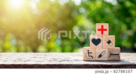 Wooden block with icon healthcare medical with copy space on green blurred backgrounds, Concept of Insurance for your health, health care, world health day. 82786107