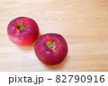 木目の上の2つのりんご　（品種　秋映） 82790916