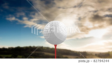 Composition of golf ball on red tee over landscape 82794244