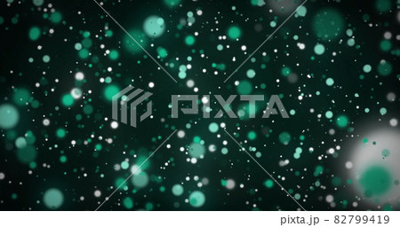Image of glowing green spots of light moving in hypnotic motion on green background 82799419
