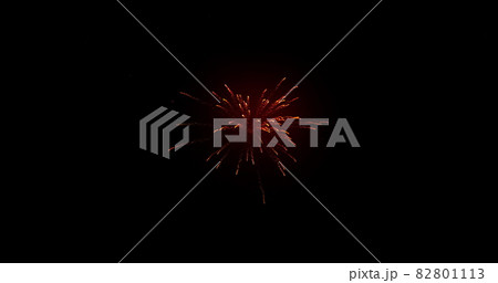 Glowing red firework exploding on black background with defocussed blue spots 82801113