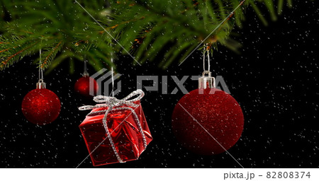 Image of red christmas baubles decoration with snow falling 82808374