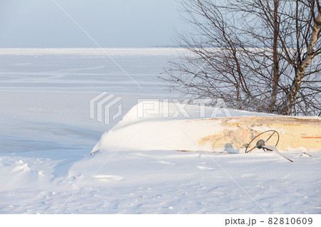 Winter landscape. Small boat lays upside down on white snow 82810609