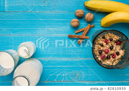 oatmeal porridge with banana, kiwi fruit, nuts and honey in a bowl with egg for healthy breakfast on rustic wooden background. top view oatmeal porridge with banana, kiwi fruit, nuts and honey in a bowl with egg for healthy breakfast on rustic wooden background. top view 82810930