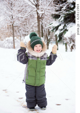 Cute child playing in a snow. Winter activities for kids. Cute child playing in a snow. Winter activities for kids. 82811964