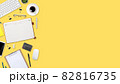flat lay workspace table with laptop computer, office supplies, coffee cup, tablet and cell phone on yellow pastel background 82816735