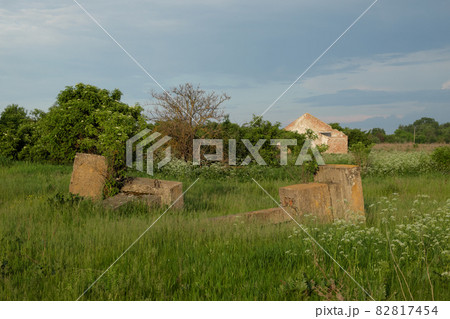 Concrete ruins on the site of an abandoned agricultural complex. Ruins overgrown with grass. Landscape. Concrete ruins on the site of an abandoned agricultural complex. Ruins overgrown with grass. Landscape. 82817454