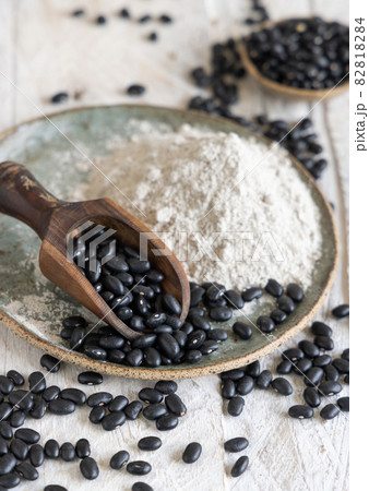 Plate with black beans flour with a wooden scoop Plate with black beans flour with a wooden scoop 82818284