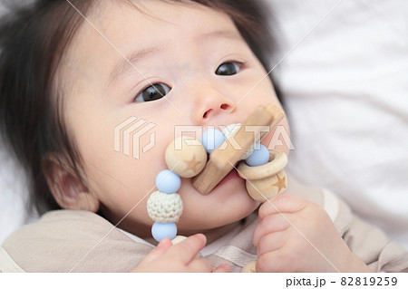 歯固めのおもちゃをかじる生後6ヶ月の赤ちゃんの女の子 82819259