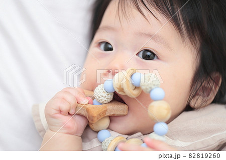 歯固めのおもちゃをかじる生後6ヶ月の赤ちゃんの女の子 82819260