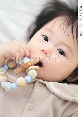 歯固めのおもちゃをかじる生後6ヶ月の赤ちゃんの女の子 82819261