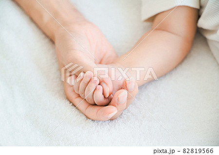 赤ちゃんの手を支えるお母さんの手 82819566