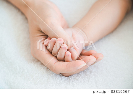 赤ちゃんの手を支えるお母さんの手 82819567