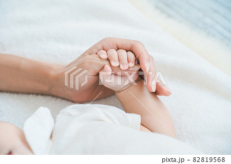 赤ちゃんの手を支えるお母さんの手 82819568