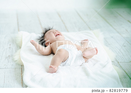 おむつ姿で泣く赤ちゃんの写真素材