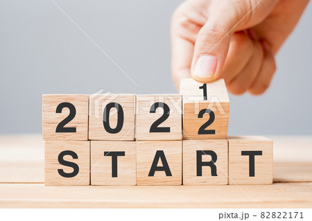 Businessman hand holding wooden cube and flip over block 2021 to 2022 START on table background. Resolution, plan, review, change ,goal and New Year holiday concepts Businessman hand holding wooden cube and flip over block 2021 to 2022 START on table background. Resolution, plan, review, change ,goal and New Year holiday concepts 82822171