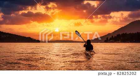Adventurous Woman on Sea Kayak paddling in the Pacific Ocean. 82825202
