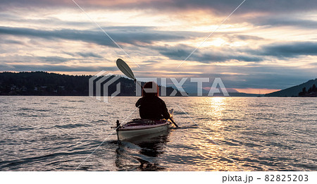 Adventurous Woman on Sea Kayak paddling in the Pacific Ocean. 82825203