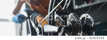 Woman repairman in rubber gloves repairing bike with tools closeup 82826568