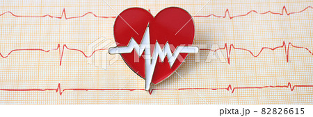 Electrocardiogram with emblem of the heart lie on table at cardiologist Electrocardiogram with emblem of the heart lie on table at cardiologist 82826615