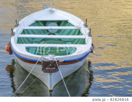 White moored boat on a river are ocean with rope and reflection White moored boat on a river are ocean with rope and reflection 82826816