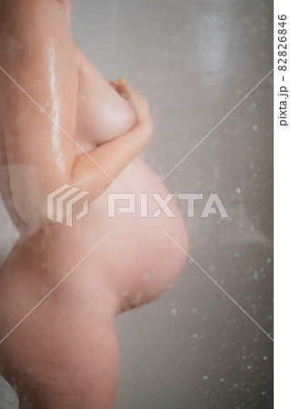 nude, undress, naked pregnant woman washes in shower. shooting through glass 82826846