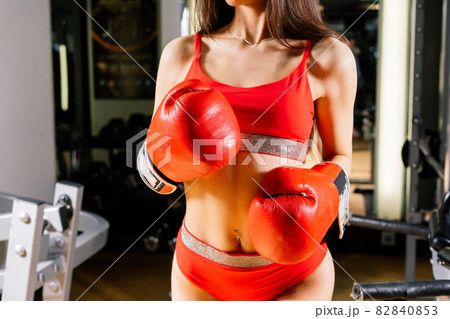 Seductive boxer model wearing big gloves and posing in fitness gym 82840853