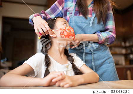 母親にマスクを着けてもらう少女 母親にマスクを着けてもらう少女 82843286