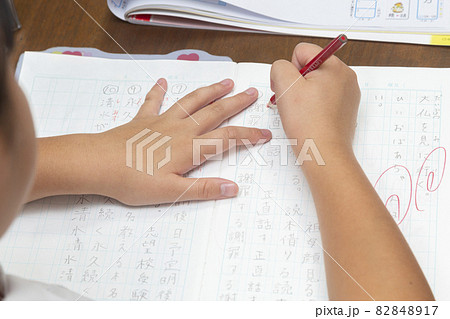 リビングで国語の宿題をする小学生の女の子の手元 82848917
