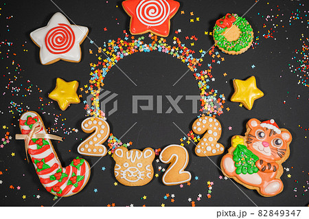 Christmas background with gingerbread on gray surface. Holiday mood card. Top view, copy space. Family traditions, DIY, celebration concept. Festive background with homemade gingerbread cookies. 82849347