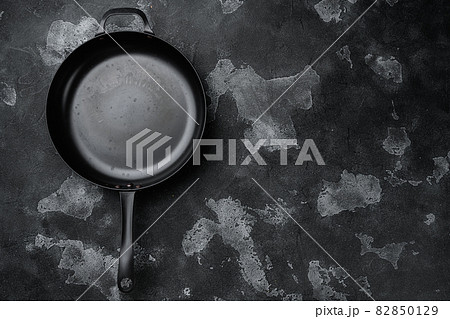 Used old empty frying pan with copy space for text or food with copy space for text or food, top view flat lay , on black dark stone table background Used old empty frying pan with copy space for text or food with copy space for text or food, top view flat lay , on black dark stone table background 82850129
