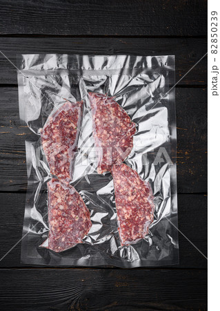 Vacuum beef or lamb mutton cutlet sealed airtight pack, on black wooden table background, top view flat lay Vacuum beef or lamb mutton cutlet sealed airtight pack, on black wooden table background, top view flat lay 82850239