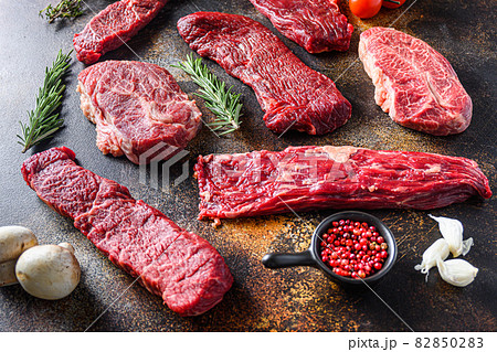 Organic set of raw alternative beef steaks flap flank Steak, machete steak or skirt cut, Top blade or flat iron beef and tri tip, triangle roast with denver cut side view over old rustic metal surface 82850283