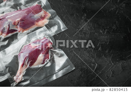 Duck meat, seasoned raw freshly slaughtered by the bio farm prepared for vacuuming and smoking , on black stone background, with copyspace and space for text 82850415