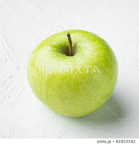Granny smith apple, on white stone table background, square format 82850582