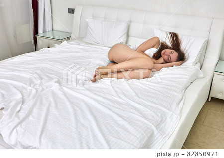 Graceful caucasian woman lies in bed and sleeps. 82850971