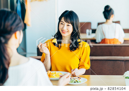 レストランで食事する若い女性 82854104