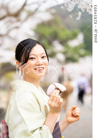 京都観光で食べ歩きを楽しんでいる女性 82854993
