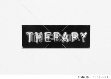 Black color banner that have embossed letter with word therapy on white paper background 82859091
