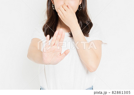 鼻をつまむTシャツを着た若い女性 82861305