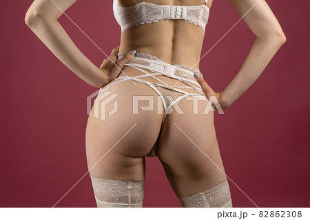 Beautiful young woman in white lace underwear of the bride posing with her back Beautiful young woman in white lace underwear of the bride posing with her back 82862308