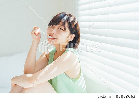 ベッドの上で歯磨きをする女性 82863663